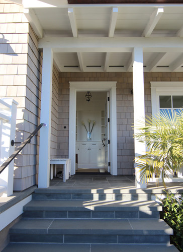 Ejemplo de puerta principal costera de tamaño medio con paredes grises, suelo de pizarra, puerta simple y puerta blanca