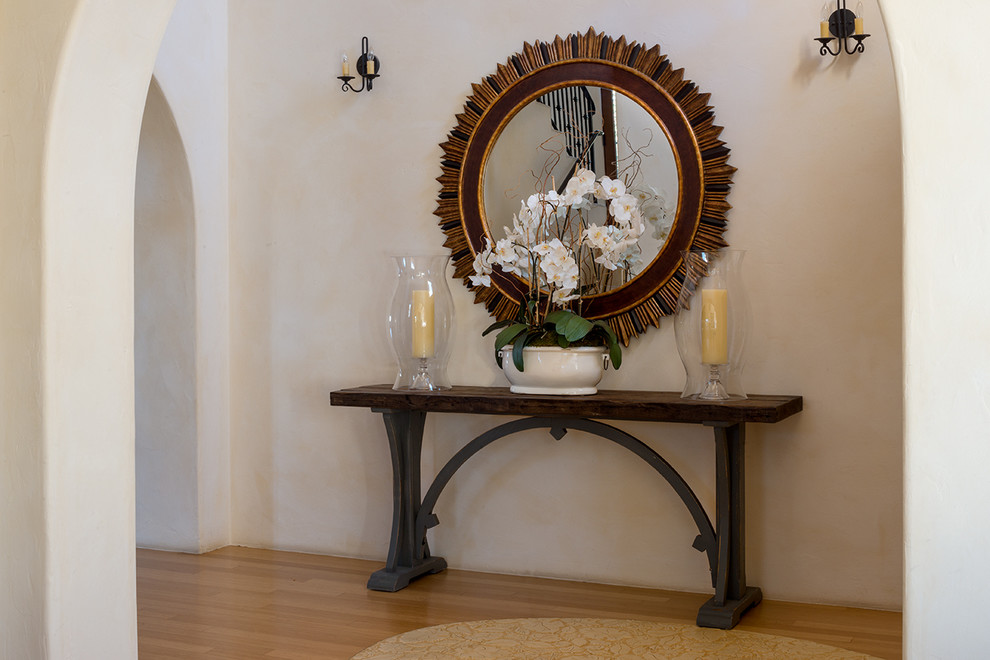 Example of a large tuscan bamboo floor entryway design in Santa Barbara with beige walls and a dark wood front door