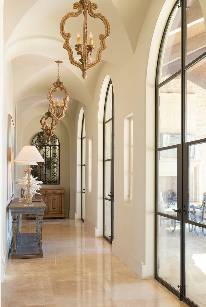 Foto de hall mediterráneo con paredes beige, puerta doble, puerta de vidrio y suelo beige