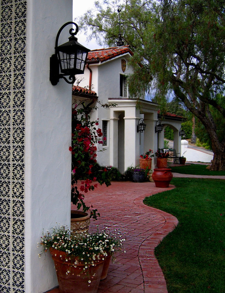 Mittelgroße Mediterrane Haustür mit weißer Wandfarbe, Einzeltür, Haustür aus Metall, Backsteinboden und rotem Boden in Santa Barbara