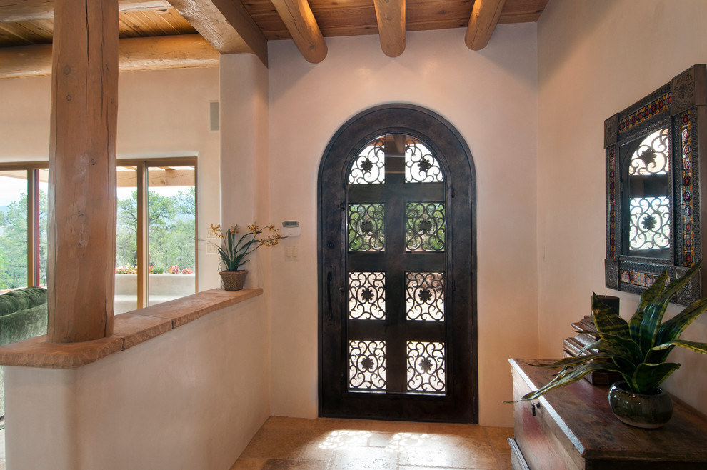 На фото: входная дверь среднего размера в средиземноморском стиле с бежевыми стенами, одностворчатой входной дверью и входной дверью из темного дерева