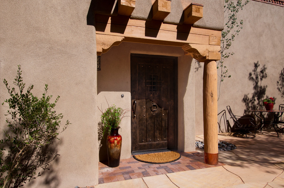 Design ideas for a medium sized mediterranean front door in Albuquerque with beige walls, a single front door and a dark wood front door.