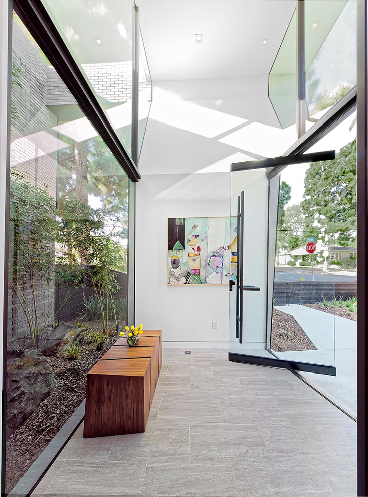 Inspiration pour une grande porte d'entrée design avec un mur blanc, un sol en carrelage de céramique, une porte pivot, une porte en verre et un sol gris.
