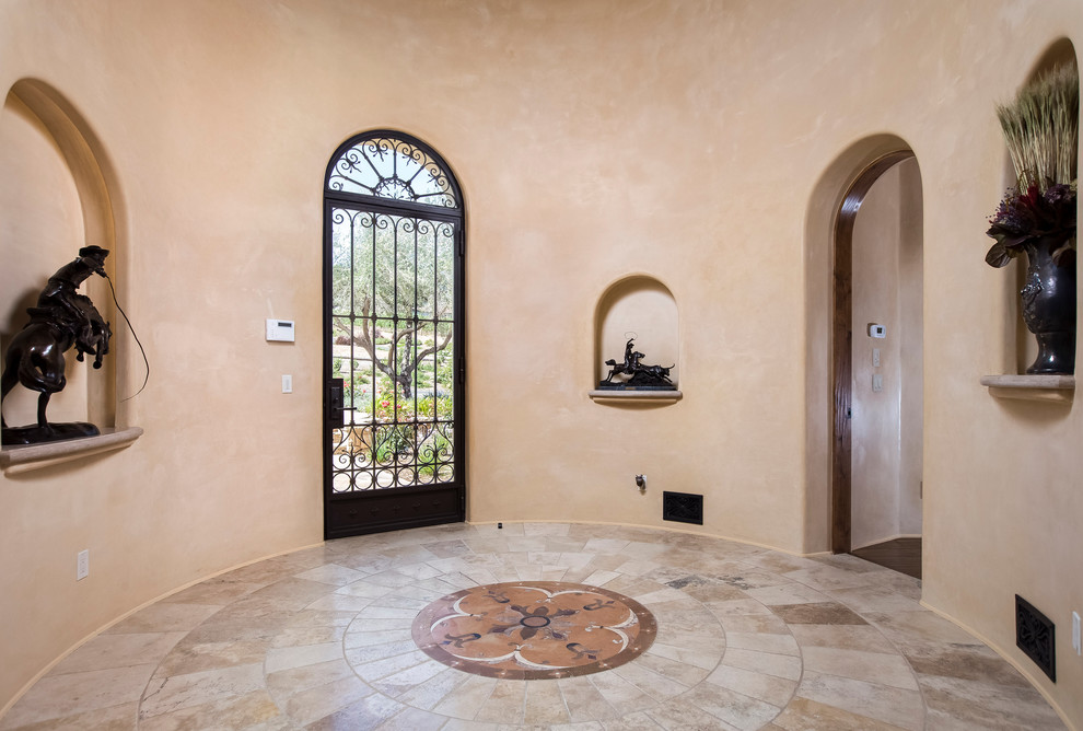 Ispirazione per un ampio ingresso american style con pareti beige, pavimento con piastrelle in ceramica, una porta singola e una porta in vetro