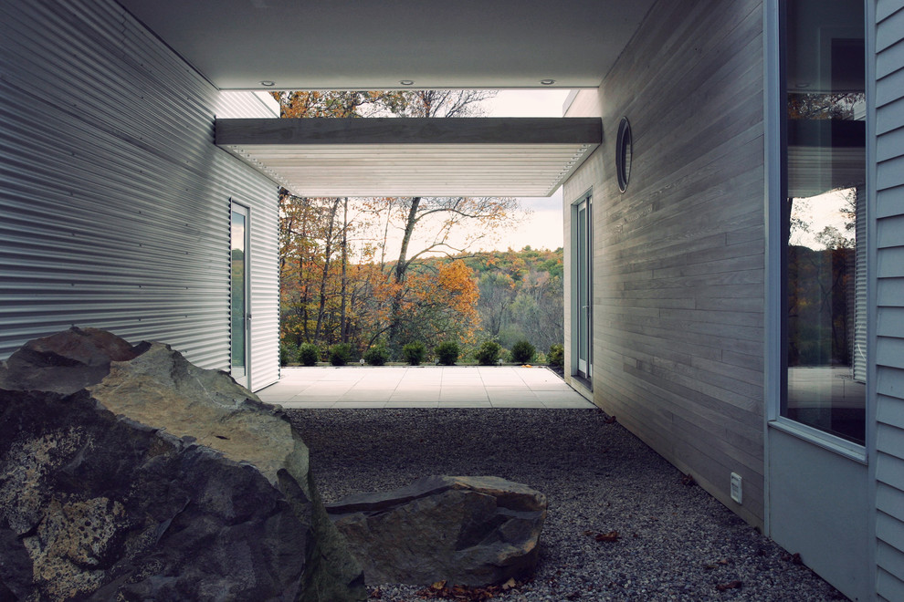 На фото: фойе в стиле модернизм с бетонным полом, белыми стенами, двустворчатой входной дверью и стеклянной входной дверью