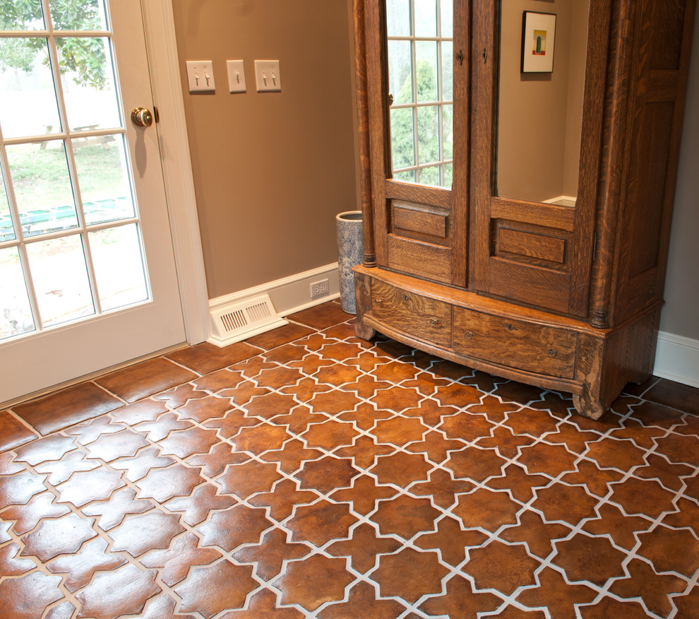 Idee per un ingresso o corridoio tradizionale di medie dimensioni con pareti marroni, pavimento con piastrelle in ceramica, una porta singola, una porta bianca e pavimento marrone