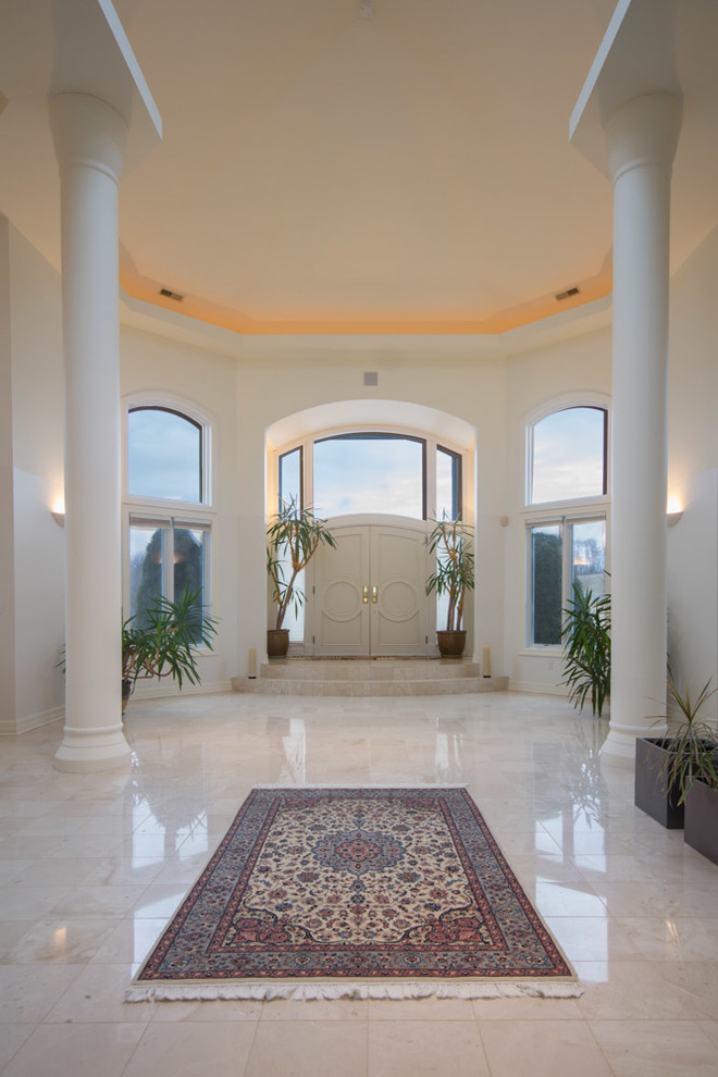 Huge marble floor entryway photo in Other with white walls and a white front door