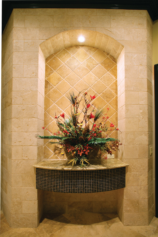 Large tuscan travertine floor entryway photo in Miami with beige walls