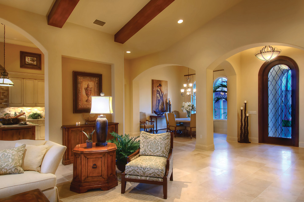 This is an example of a large mediterranean foyer in Miami with beige walls, travertine flooring, a single front door and a medium wood front door.