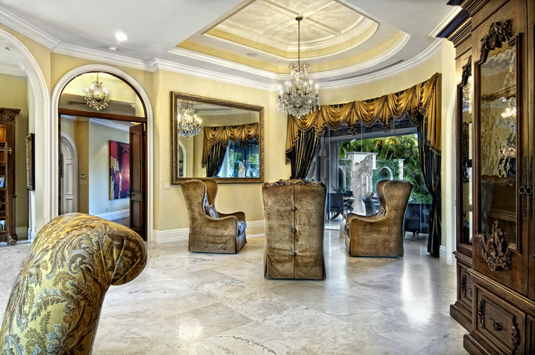 Large mediterranean foyer in Miami with beige walls, travertine flooring, a double front door and a dark wood front door.