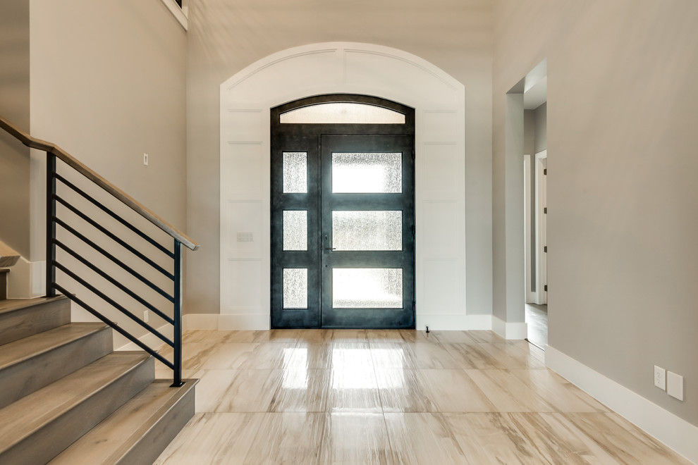 Стильный дизайн: фойе среднего размера в стиле неоклассика (современная классика) с серыми стенами, полом из травертина, одностворчатой входной дверью, металлической входной дверью и коричневым полом - последний тренд