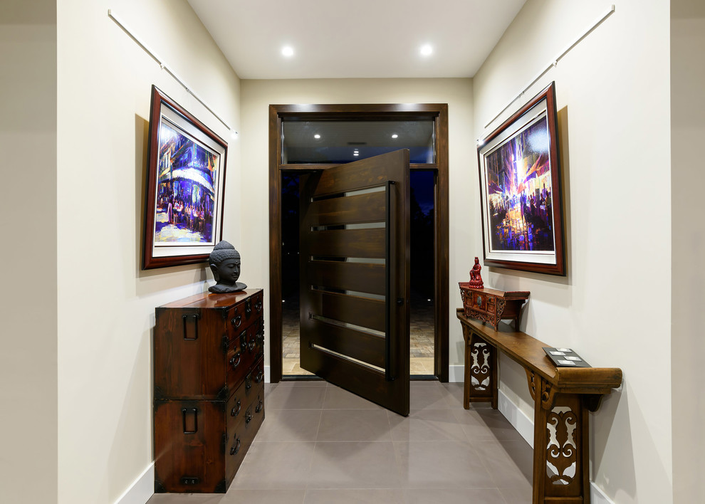 ジャクソンビルにあるラグジュアリーな広いアジアンスタイルのおしゃれな玄関ドア (白い壁、磁器タイルの床、濃色木目調のドア、グレーの床) の写真