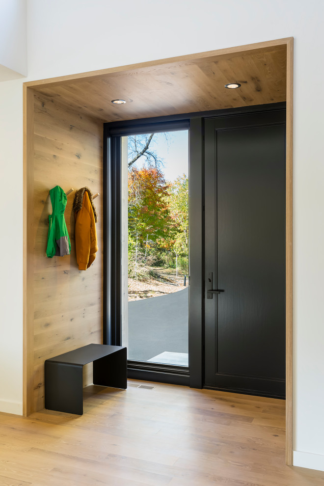 Mid-sized danish light wood floor, beige floor, wood ceiling and wood wall entryway photo in Minneapolis with white walls and a black front door