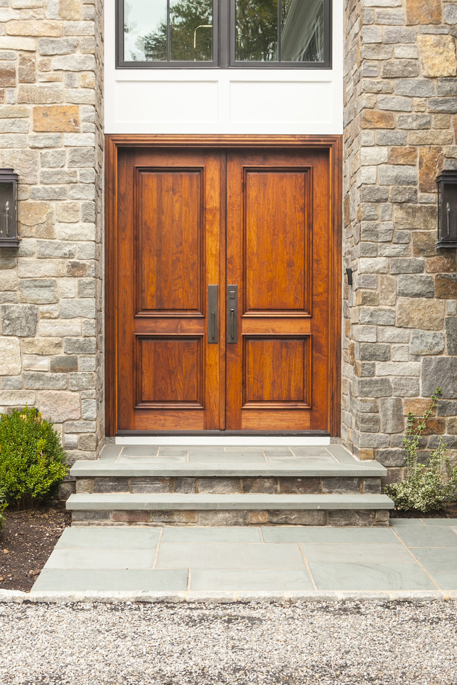 Imagen de puerta principal clásica renovada grande con puerta doble y puerta de madera en tonos medios