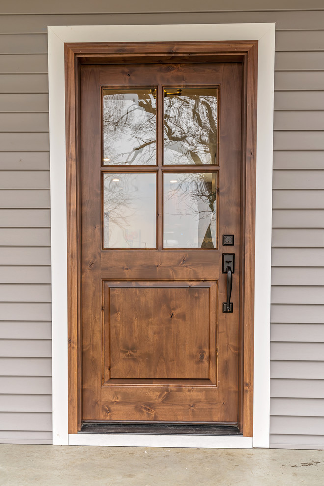 Exemple d'une porte d'entrée nature avec un mur gris, une porte simple et une porte en bois brun.