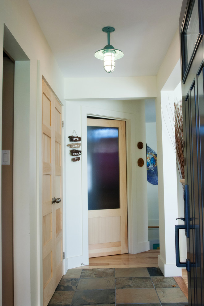 Example of a mid-sized beach style slate floor entryway design in Toronto with white walls and a black front door