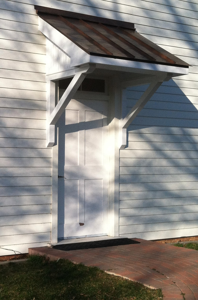 Immagine di una piccola porta d'ingresso country con pareti bianche, una porta singola e una porta bianca