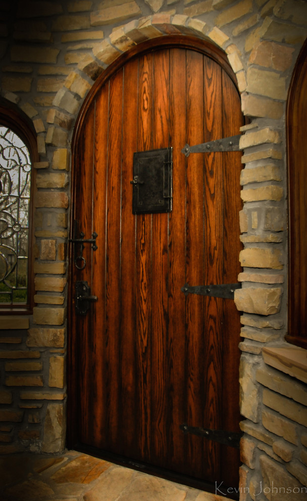 На фото: прихожая в стиле рустика с бежевыми стенами, полом из сланца, одностворчатой входной дверью и входной дверью из темного дерева
