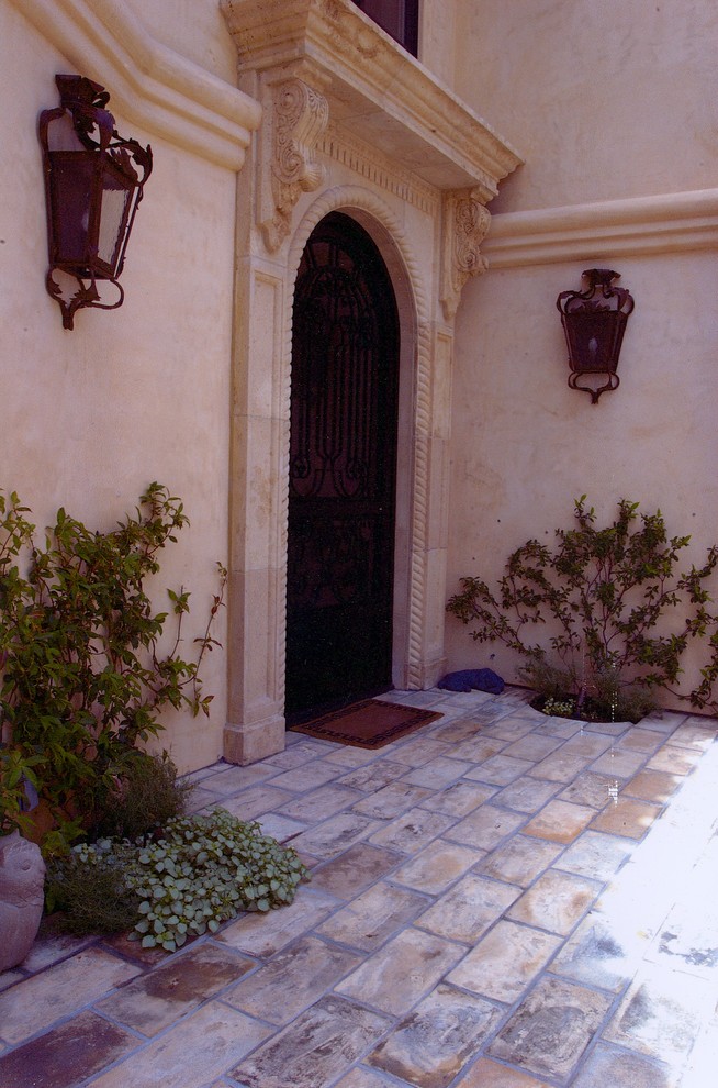 Идея дизайна: входная дверь среднего размера в средиземноморском стиле с бежевыми стенами, бетонным полом, одностворчатой входной дверью и входной дверью из темного дерева