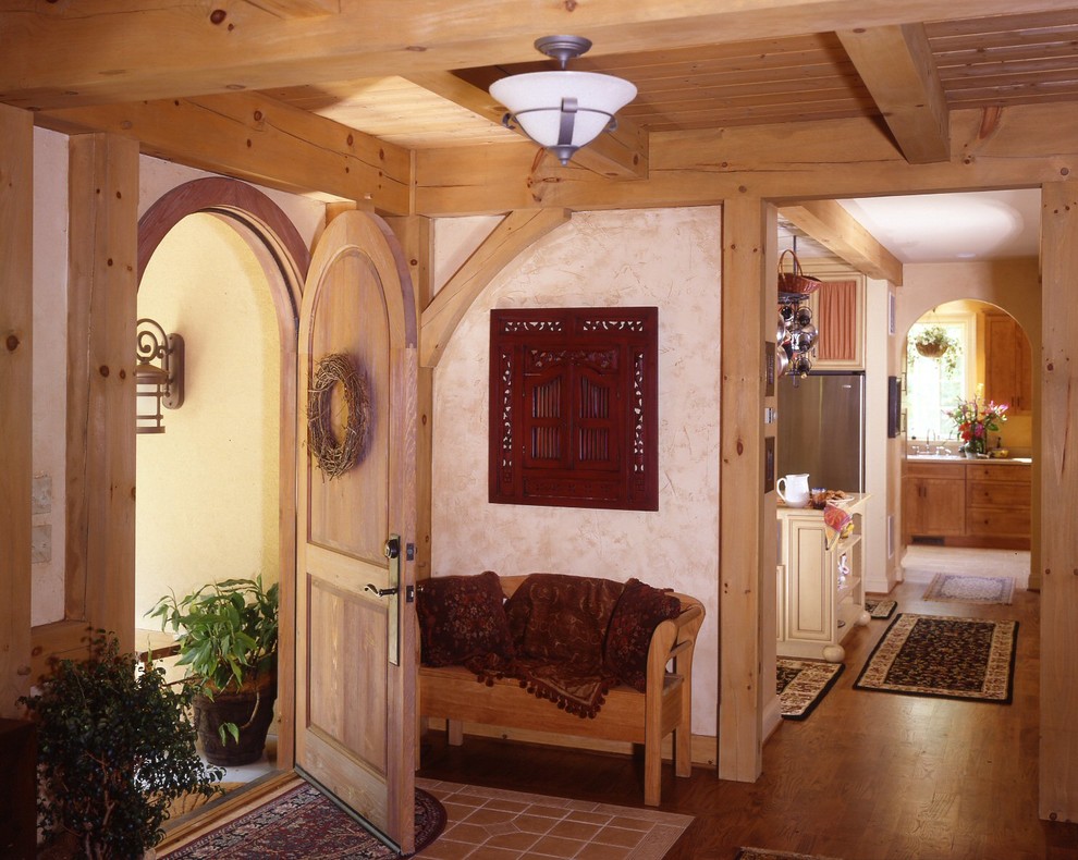 Imagen de distribuidor mediterráneo de tamaño medio con paredes beige, suelo de madera en tonos medios, puerta simple y puerta de madera en tonos medios