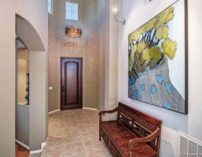 Entryway - contemporary porcelain tile entryway idea in San Diego with brown walls and a dark wood front door