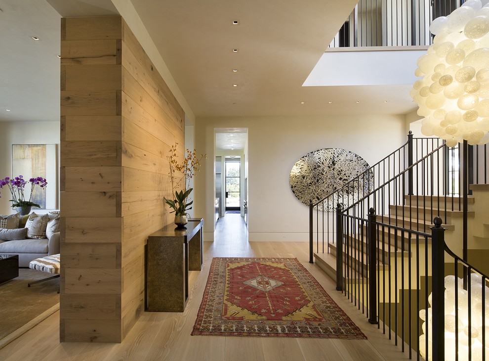 Example of a mid-sized trendy light wood floor and beige floor foyer design in San Francisco with white walls