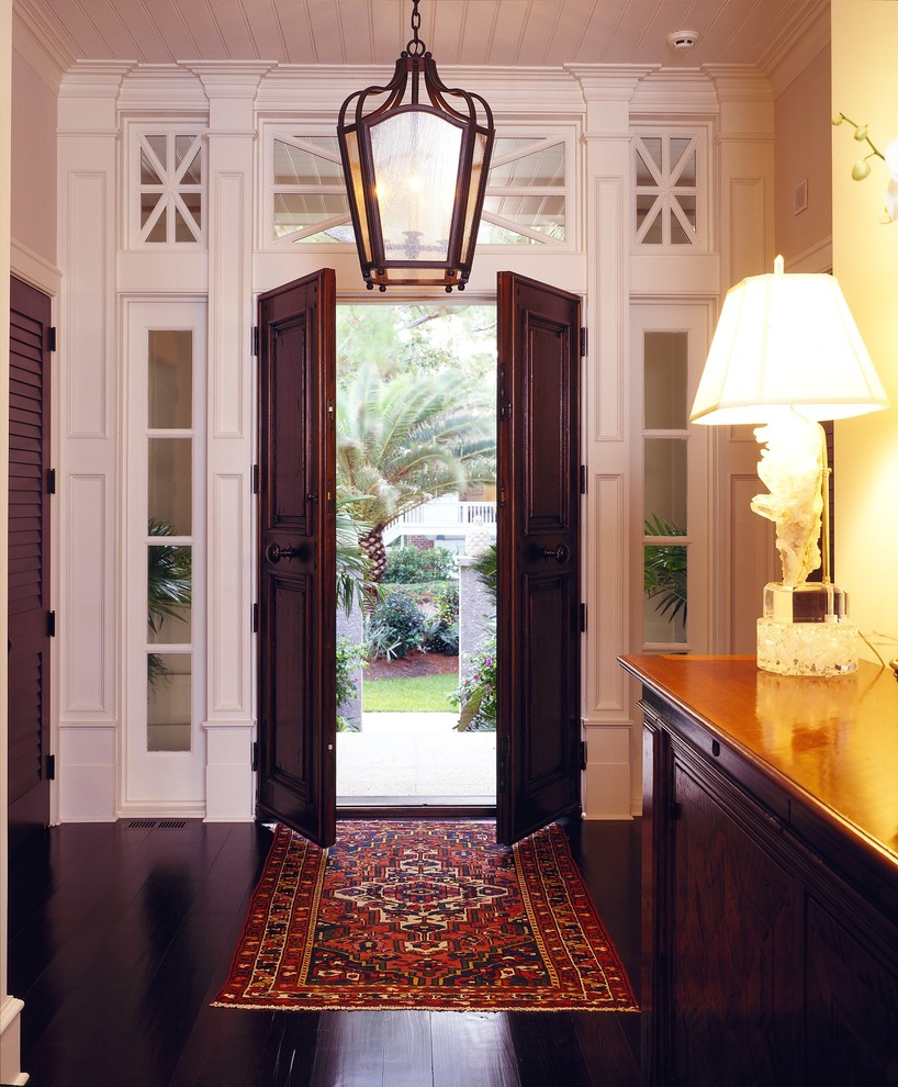 Ejemplo de entrada tradicional con puerta doble y puerta de madera oscura