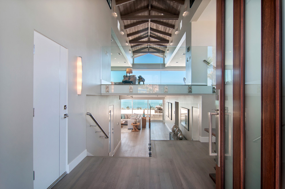 Großes Modernes Foyer mit grauer Wandfarbe, hellem Holzboden, Einzeltür und hellbrauner Holzhaustür in San Diego