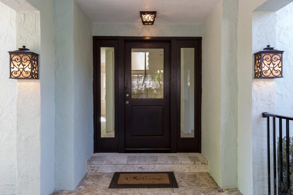 マイアミにある地中海スタイルのおしゃれな玄関ドア (緑の壁、ライムストーンの床、茶色いドア) の写真