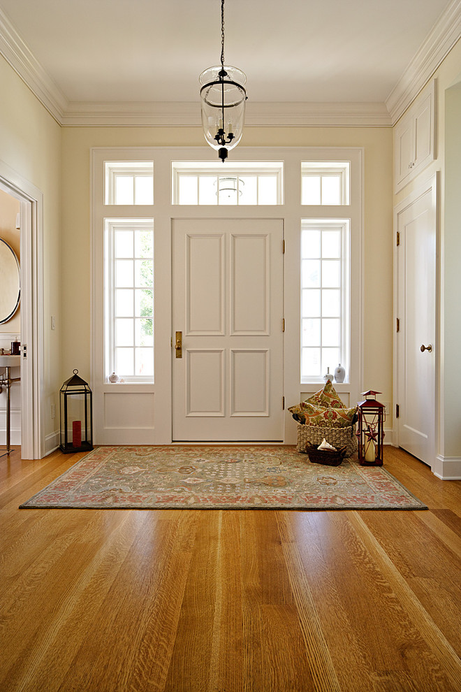 Ispirazione per una porta d'ingresso stile marino di medie dimensioni con pareti bianche, pavimento in legno massello medio, una porta singola, una porta bianca e pavimento beige