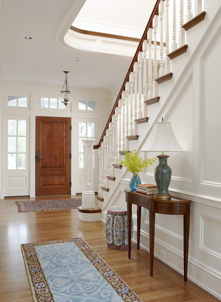 Design ideas for a large classic foyer in Boston with a single front door, a medium wood front door, white walls, medium hardwood flooring, brown floors and a dado rail.