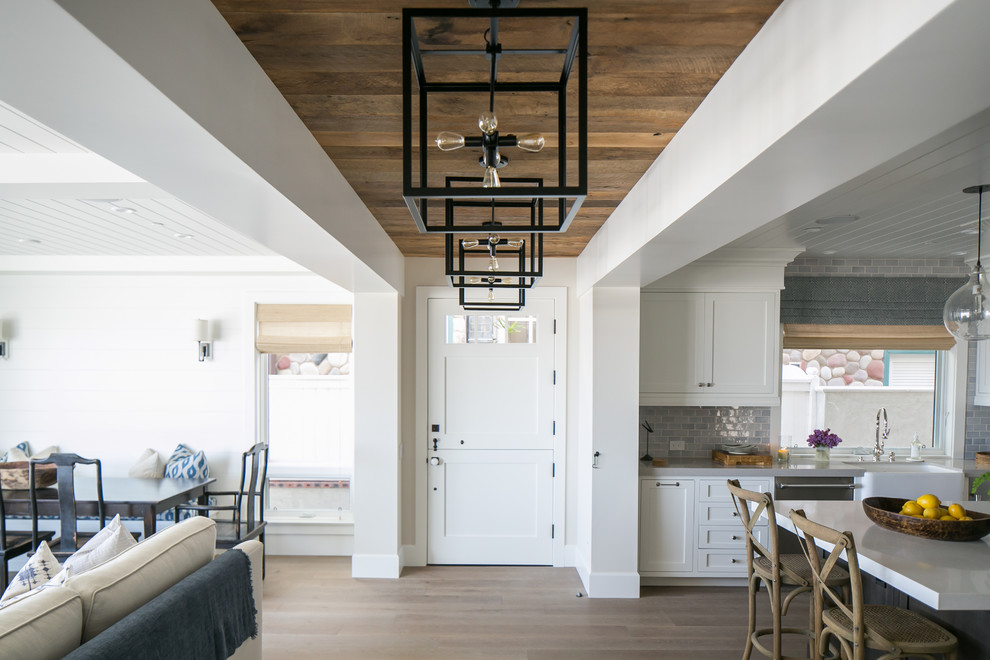 Beach style light wood floor entryway photo in Orange County with gray walls and a white front door
