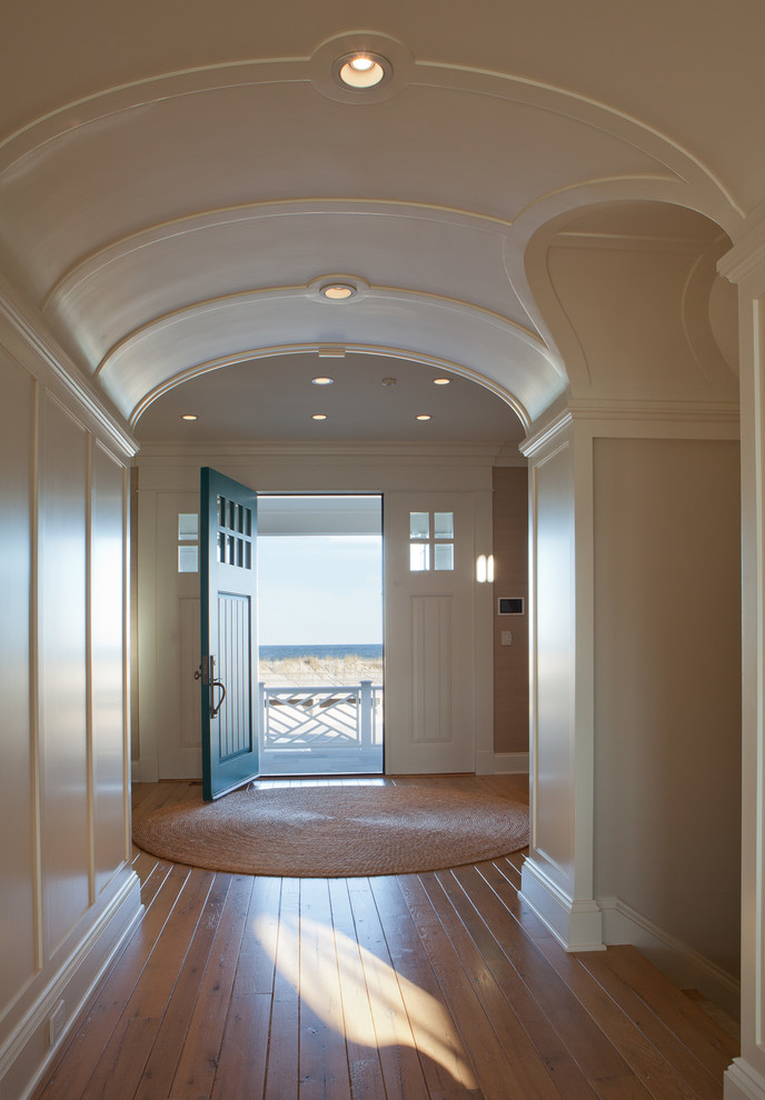 На фото: входная дверь среднего размера: освещение в морском стиле с бежевыми стенами, паркетным полом среднего тона, одностворчатой входной дверью, зеленой входной дверью и коричневым полом с