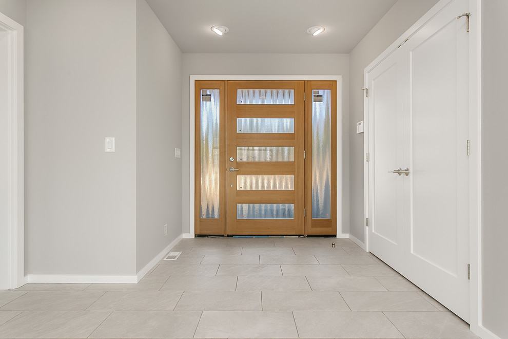 Design ideas for a medium sized modern foyer in Seattle with grey walls, porcelain flooring, a single front door and a light wood front door.