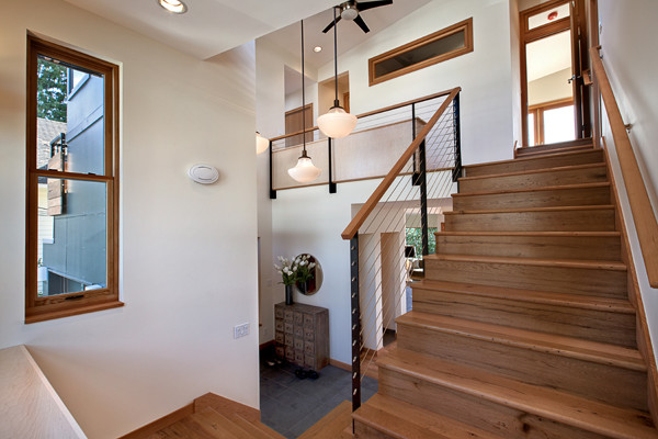 Ispirazione per un ingresso moderno di medie dimensioni con pareti bianche, pavimento in legno massello medio, una porta singola e una porta in legno bruno