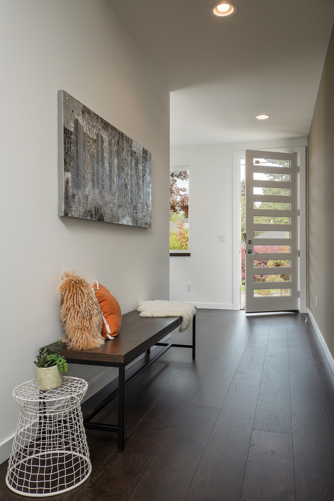 Design ideas for a contemporary hallway in Seattle with white walls, dark hardwood flooring, a single front door, a white front door and black floors.