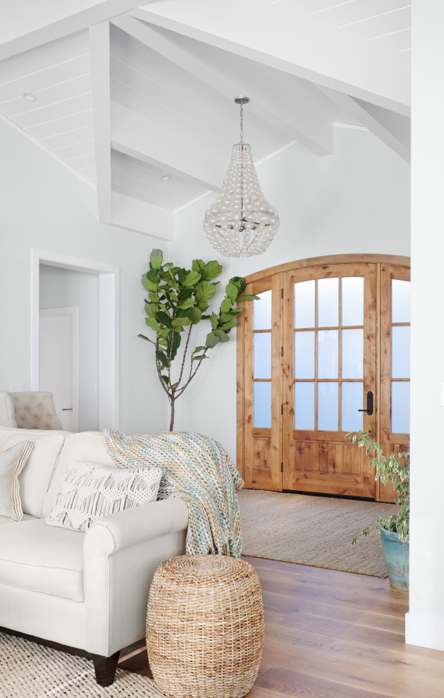 Large beach style light wood floor and brown floor entryway photo in San Francisco with white walls and a glass front door