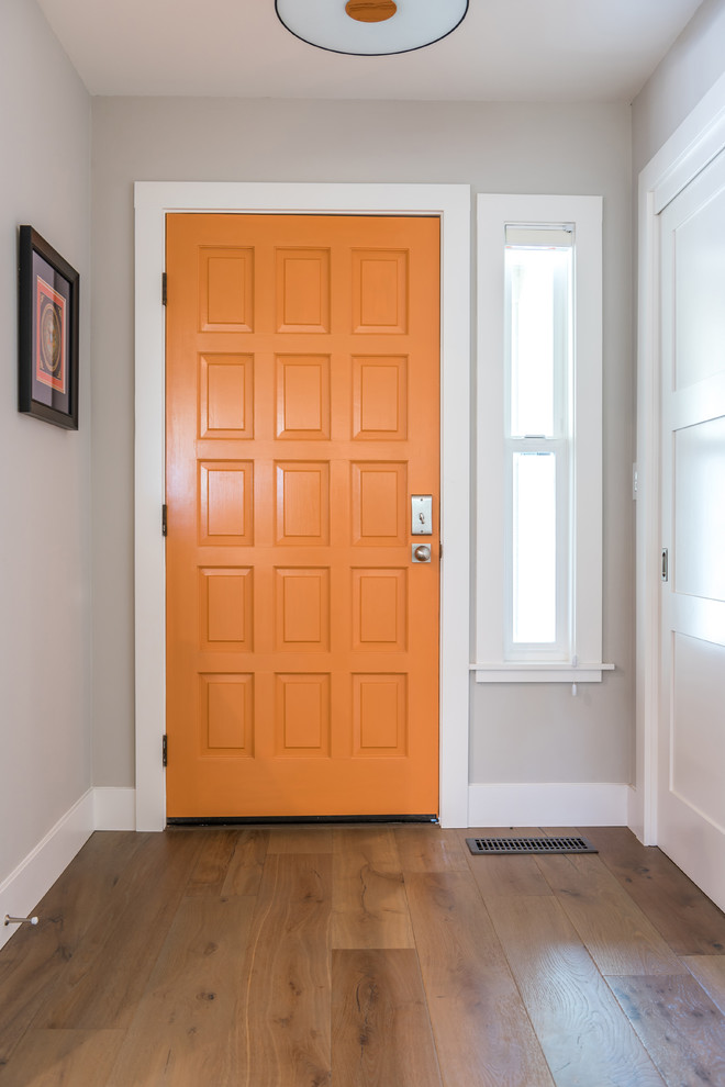 Idéer för att renovera en funkis entré, med grå väggar, mellanmörkt trägolv, en enkeldörr och en orange dörr