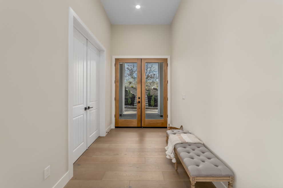 Idées déco pour une grande porte d'entrée classique avec un mur beige, parquet clair, une porte double, une porte en verre et un sol marron.