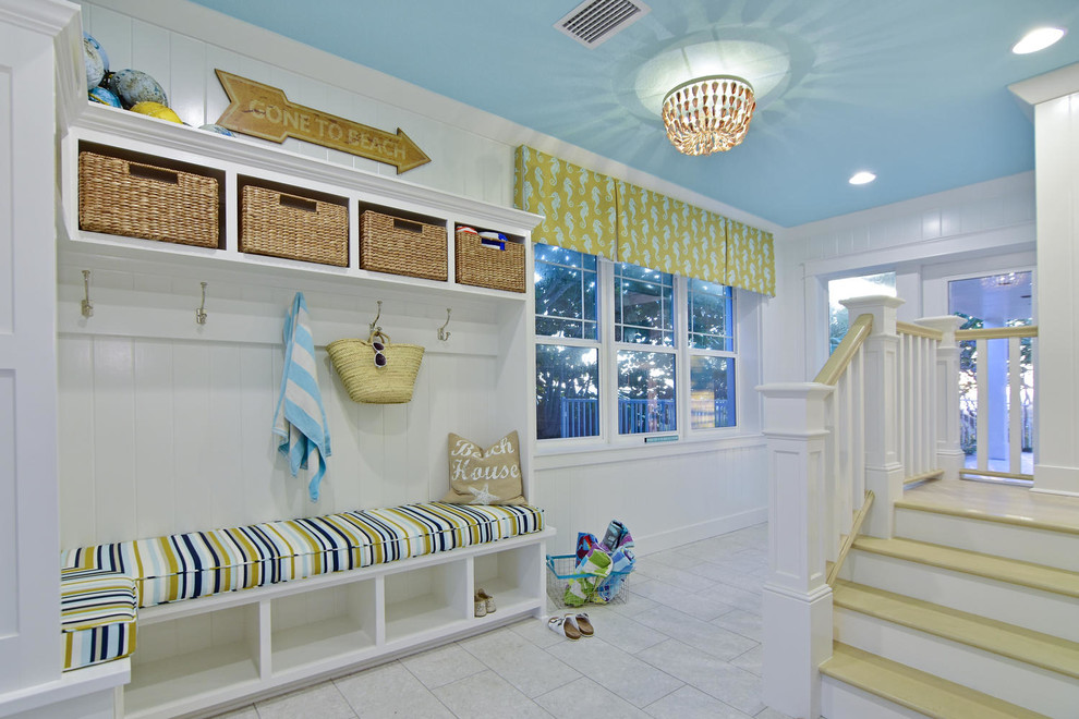 Example of a large beach style entryway design in Tampa with white walls and a white front door