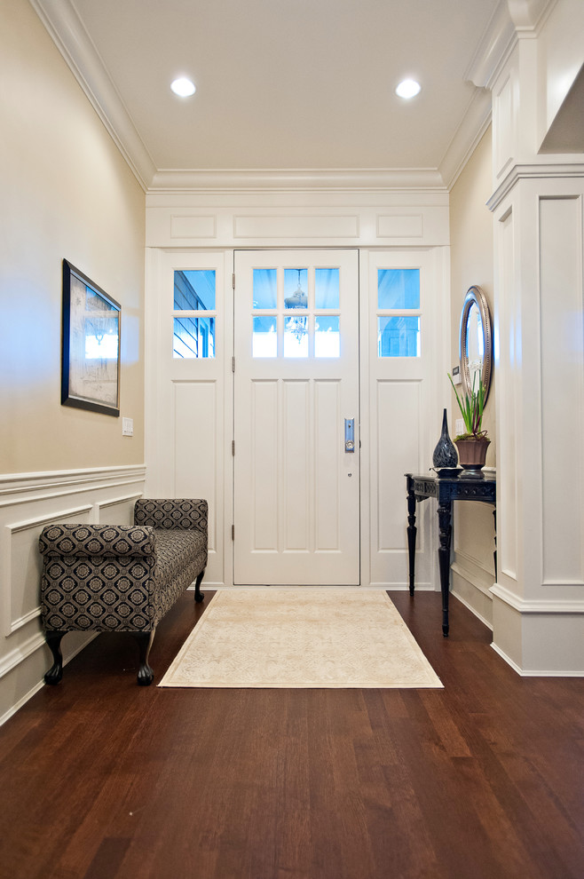 Свежая идея для дизайна: узкая прихожая среднего размера в классическом стиле с бежевыми стенами, темным паркетным полом, раздвижной входной дверью, белой входной дверью и коричневым полом - отличное фото интерьера