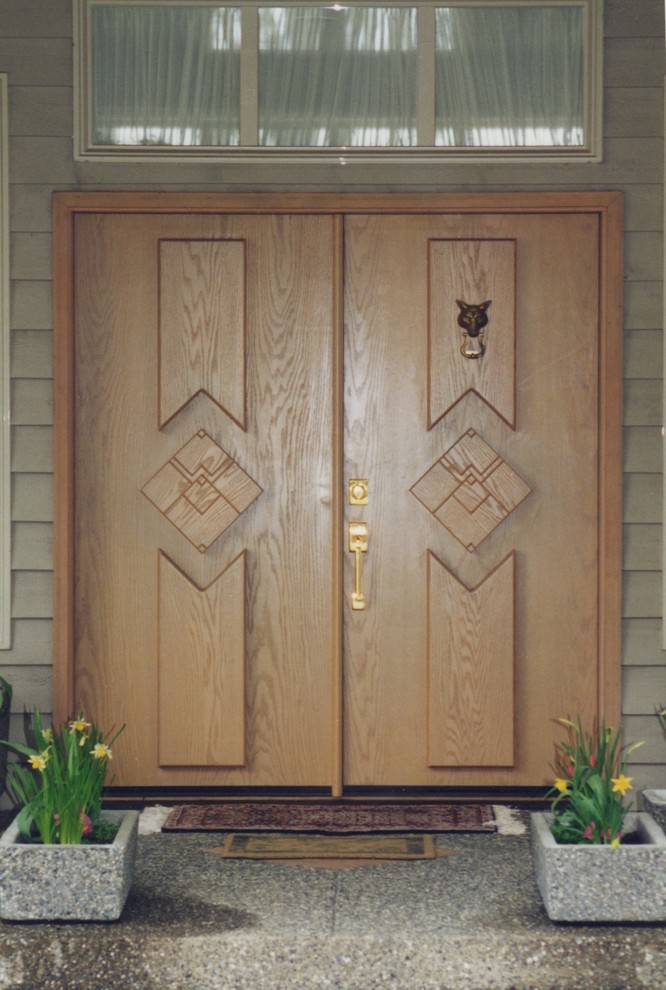 Diseño de puerta principal contemporánea extra grande con paredes marrones, suelo de madera clara, puerta doble y puerta de madera en tonos medios