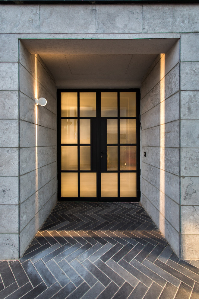 This is an example of a medium sized contemporary foyer in Tel Aviv with black walls, porcelain flooring, a double front door, a glass front door and grey floors.