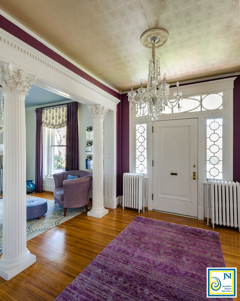 На фото: фойе среднего размера в классическом стиле с фиолетовыми стенами, паркетным полом среднего тона, одностворчатой входной дверью, белой входной дверью и коричневым полом с
