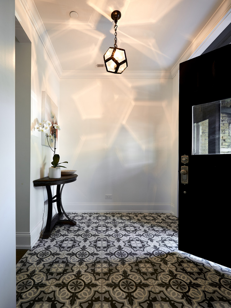 This is an example of a traditional foyer in Chicago with white walls, a single front door and a black front door.