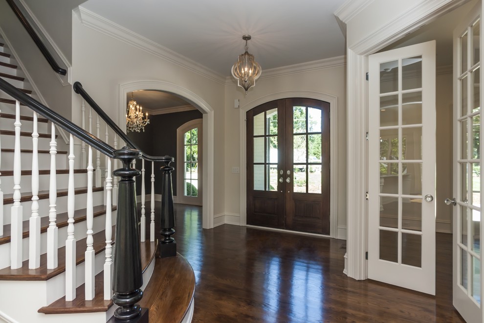 Klassisches Foyer mit weißer Wandfarbe, dunklem Holzboden, Doppeltür und dunkler Holzhaustür in Raleigh