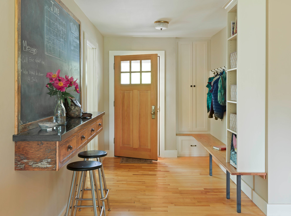 Landhausstil Eingang mit beiger Wandfarbe, braunem Holzboden, Einzeltür, hellbrauner Holzhaustür und braunem Boden in Burlington