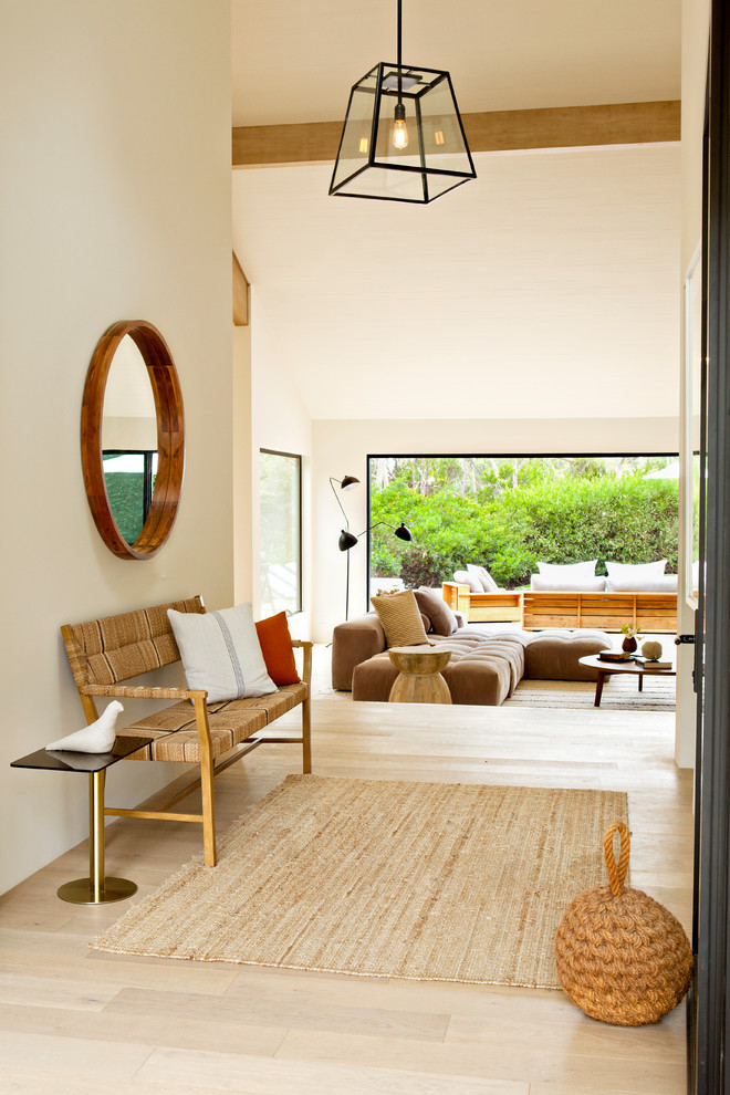 Esempio di un ingresso minimal con pareti beige, parquet chiaro e pavimento beige