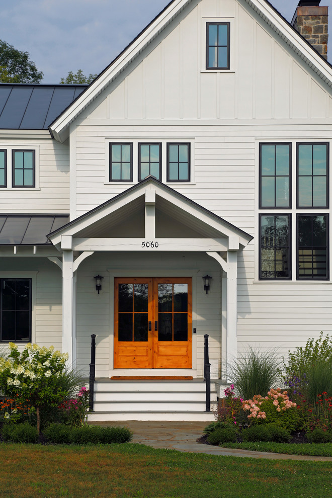Example of a cottage entryway design in Boston with a glass front door