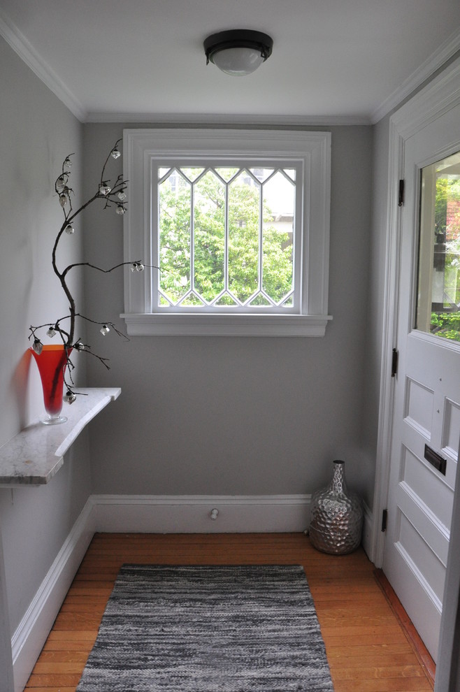 Idéer för en liten klassisk farstu, med grå väggar, ljust trägolv, en enkeldörr och en vit dörr